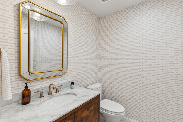 9736 Chiswell Rd, Dallas, TX 75238 - bathroom featuring wallpapered walls, toilet, and vanity