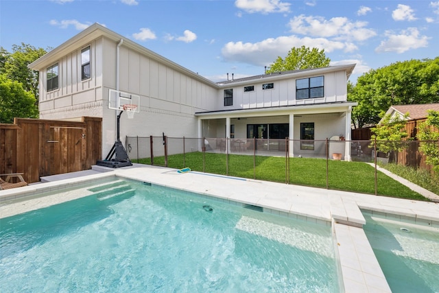 9736 Chiswell Rd, Dallas, TX 75238 - back of house with board and batten siding, a patio, a fenced in pool, fence, and a yard