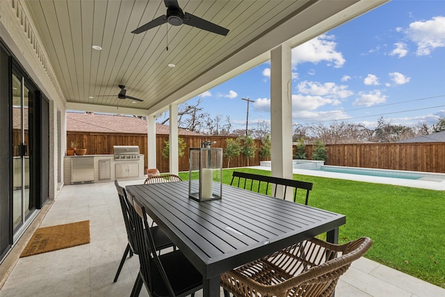 view of patio / terrace with ceiling fan, a fenced in pool, an outdoor kitchen, and a grill