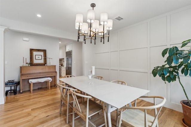 dining space featuring a notable chandelier and light hardwood / wood-style flooring