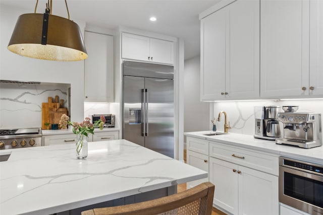 kitchen featuring white cabinetry, pendant lighting, backsplash, and stainless steel built in refrigerator