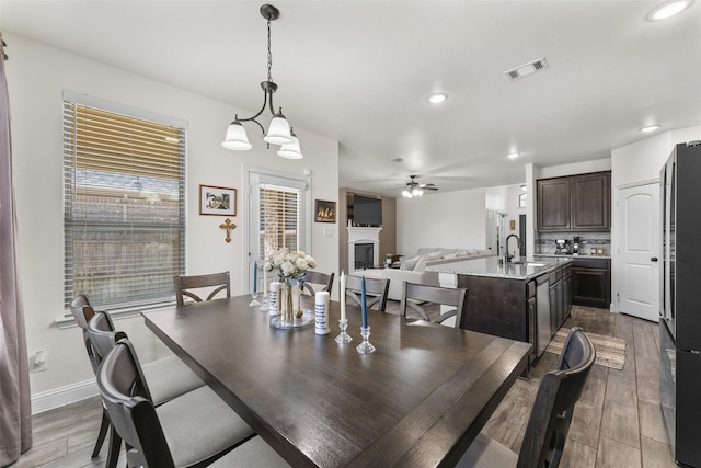 dining room featuring ceiling fan with notable chandelier and sink