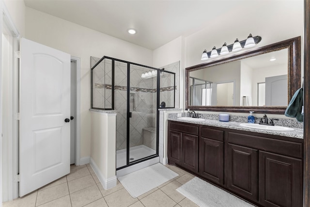 bathroom with walk in shower, vanity, and tile patterned flooring