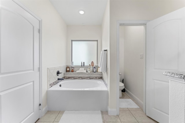 bathroom with toilet, a bathing tub, and tile patterned flooring