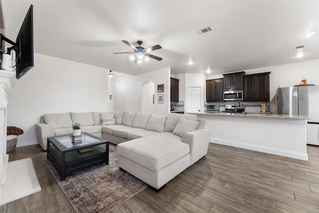 living room with ceiling fan and sink