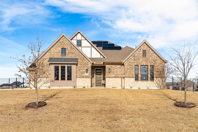 view of front facade with a front lawn and solar panels