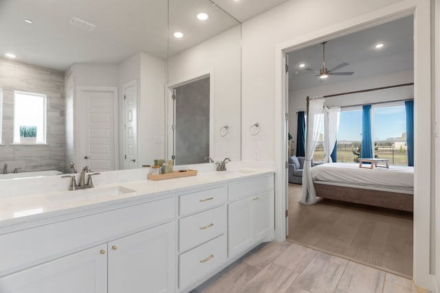 full bath with double vanity, ceiling fan, ensuite bath, and a sink