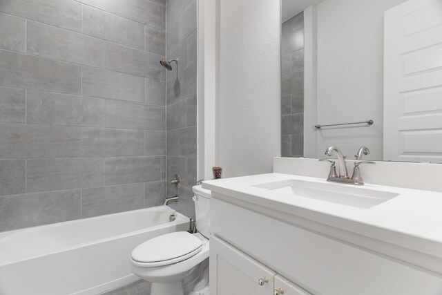 full bathroom featuring toilet, tiled shower / bath combo, and vanity