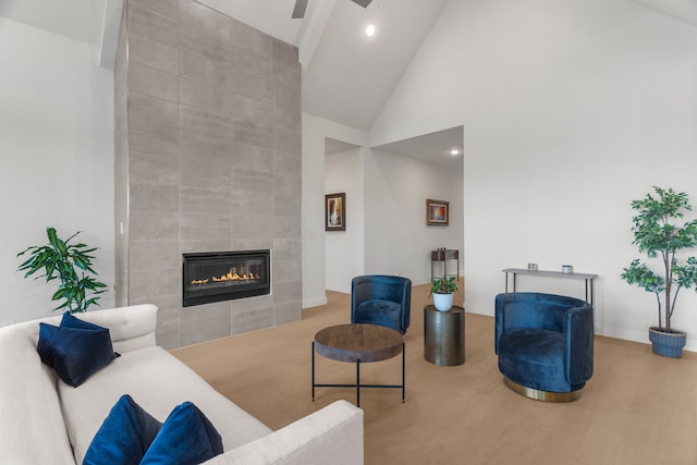 living room featuring high vaulted ceiling, hardwood / wood-style flooring, and a fireplace