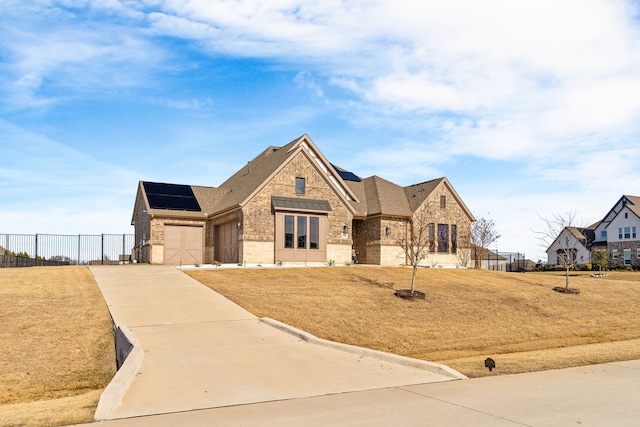 view of front of property featuring a front lawn and solar panels