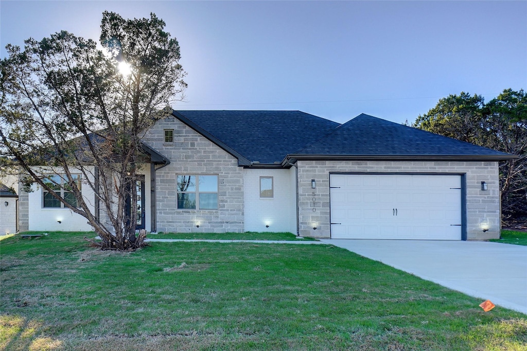 single story home with a front yard and a garage