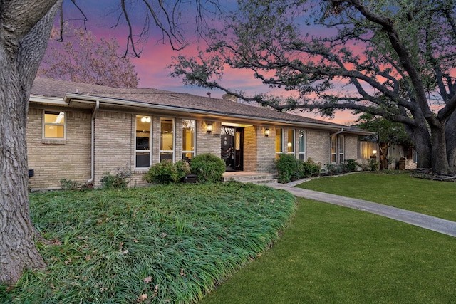 ranch-style home with a yard