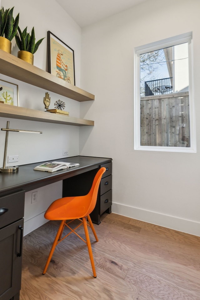 office area featuring built in desk and light hardwood / wood-style floors