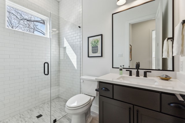 bathroom with walk in shower, vanity, and toilet