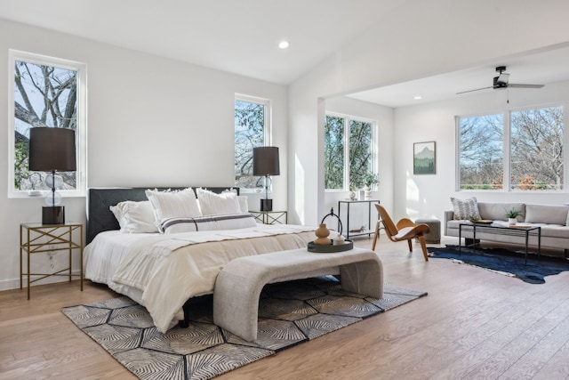 living room featuring wood-type flooring, ceiling fan, and a wealth of natural light