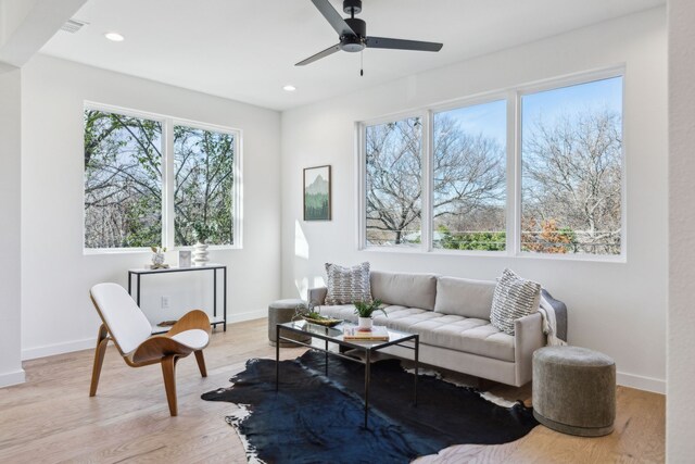 living room featuring light hardwood / wood-style flooring and ceiling fan