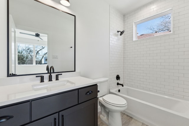 full bathroom featuring vanity, toilet, tiled shower / bath, and plenty of natural light