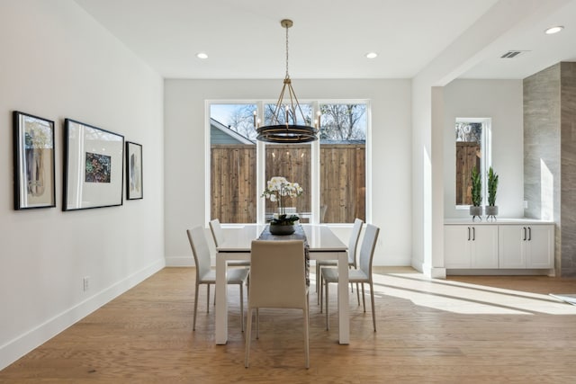 dining area with a chandelier and light wood-type flooring