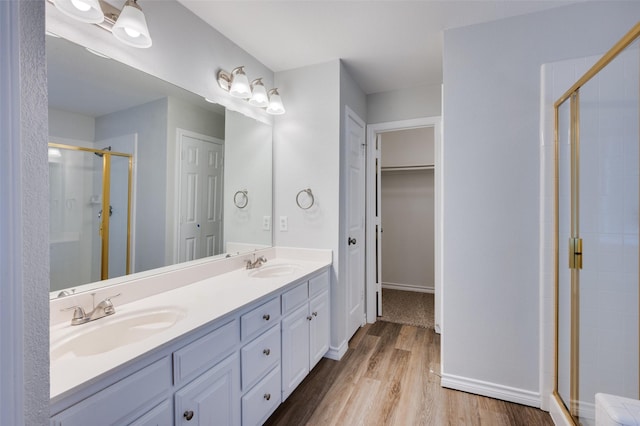 bathroom featuring hardwood / wood-style flooring, walk in shower, and vanity