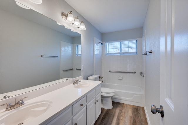 full bathroom with toilet, tiled shower / bath combo, vanity, and hardwood / wood-style floors