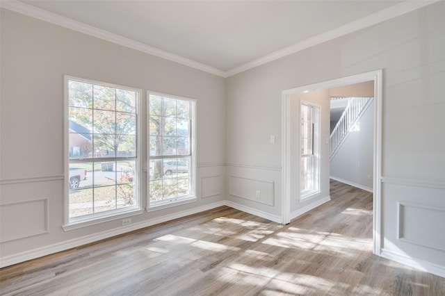 spare room featuring light hardwood / wood-style flooring and crown molding