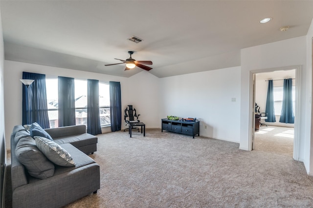 carpeted living room with ceiling fan, lofted ceiling, and a healthy amount of sunlight