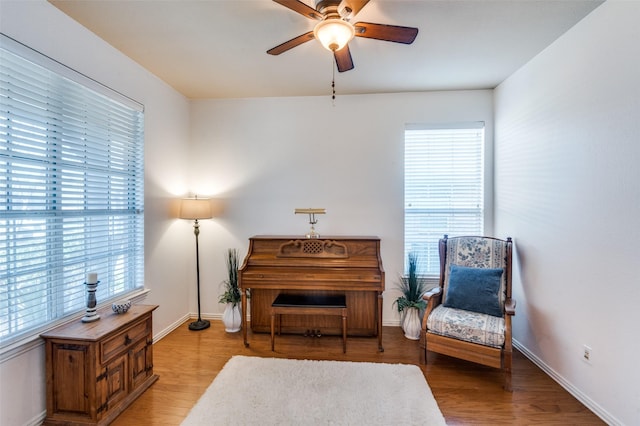 living area featuring light wood-type flooring, ceiling fan, and plenty of natural light