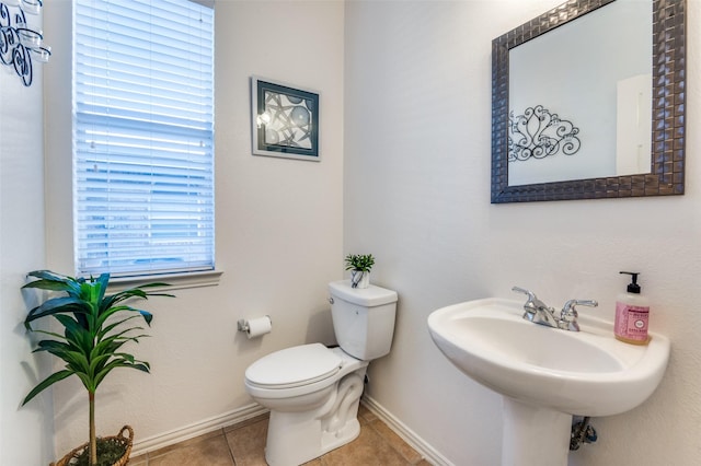 bathroom with sink, toilet, and tile patterned flooring