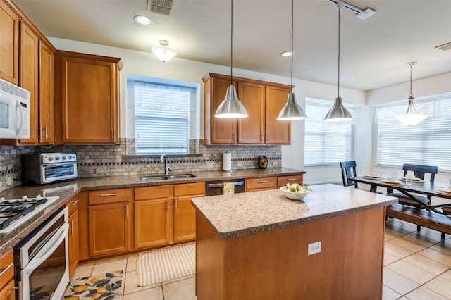 kitchen featuring sink, pendant lighting, a center island, and stainless steel appliances