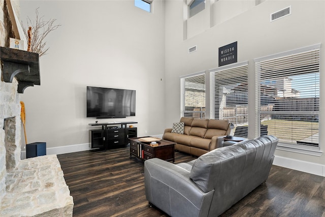 living area with baseboards, visible vents, and dark wood-style flooring