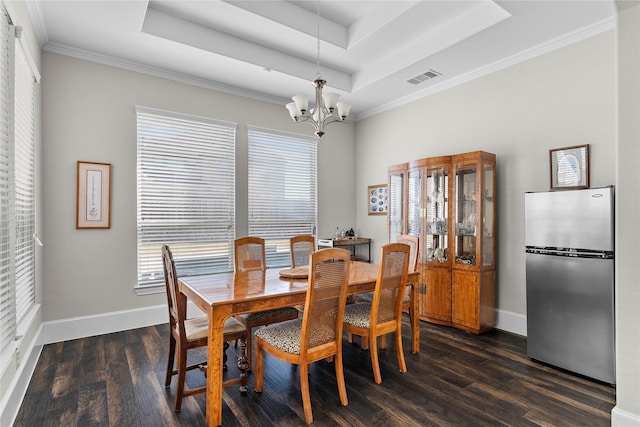 dining area with dark wood-style floors, a tray ceiling, a chandelier, and visible vents