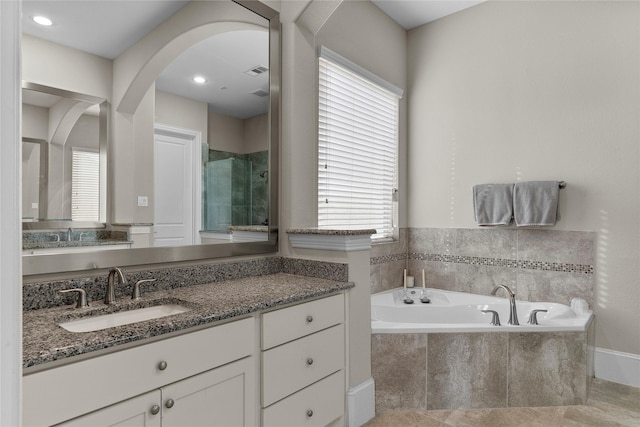 full bath with a stall shower, a garden tub, visible vents, and vanity