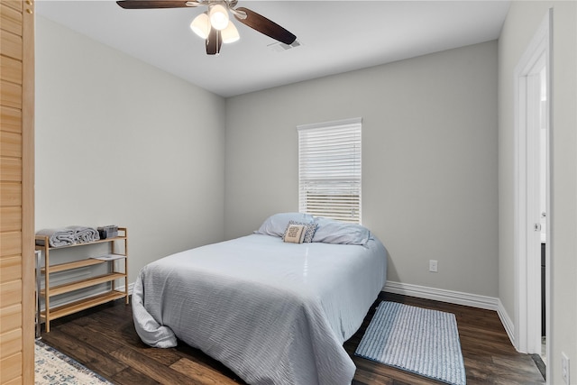 bedroom with a ceiling fan, wood finished floors, visible vents, and baseboards