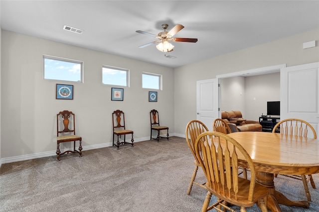 carpeted dining room featuring ceiling fan, visible vents, and baseboards