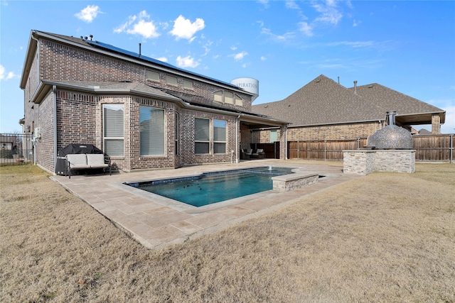 rear view of house with a patio area, a fenced backyard, and brick siding