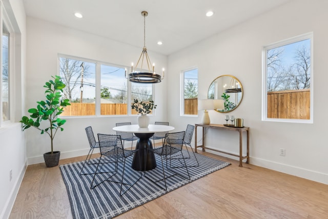 dining room featuring hardwood / wood-style flooring, a wealth of natural light, and a notable chandelier