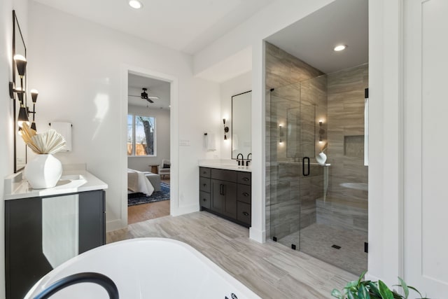 bathroom featuring ceiling fan, a shower with shower door, wood-type flooring, and vanity