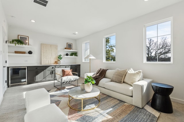 carpeted living room featuring wine cooler