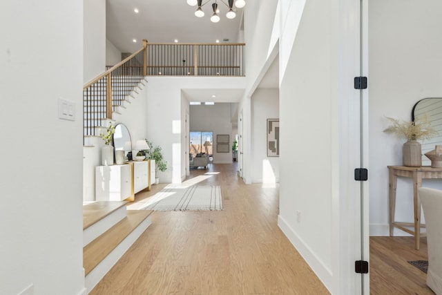 entryway featuring a towering ceiling and light hardwood / wood-style flooring