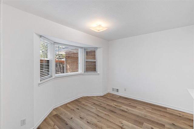 empty room with light hardwood / wood-style flooring