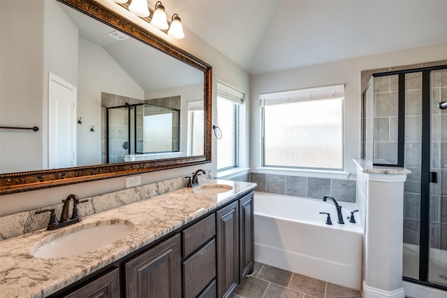 bathroom featuring independent shower and bath, vanity, lofted ceiling, and tile patterned floors