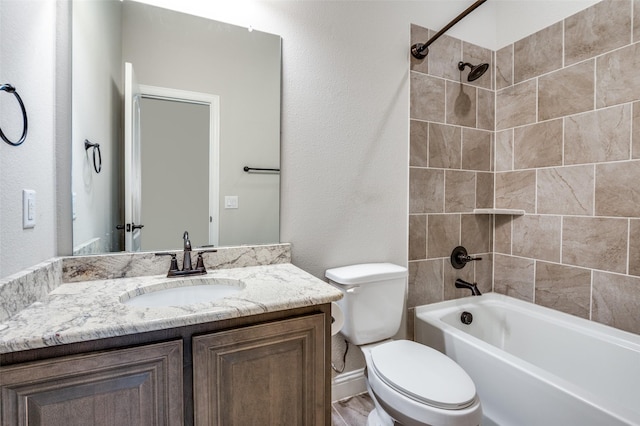 full bathroom featuring tiled shower / bath combo, vanity, and toilet