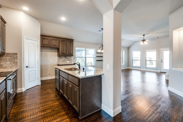 kitchen featuring tasteful backsplash, lofted ceiling, sink, light stone counters, and stainless steel appliances