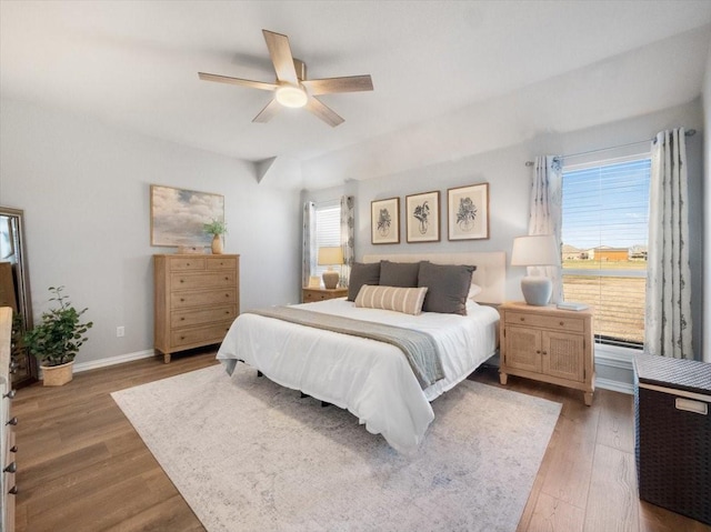 bedroom featuring a baseboard heating unit, ceiling fan, and wood-type flooring