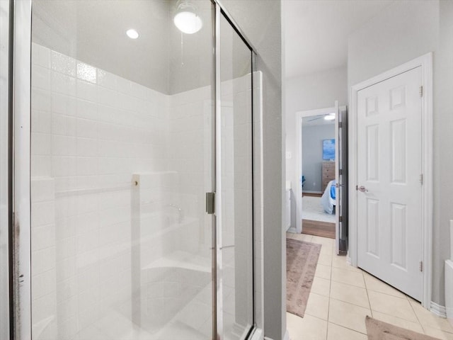 bathroom with a shower with shower door and tile patterned floors