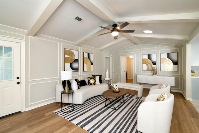 living room featuring ceiling fan, hardwood / wood-style floors, and lofted ceiling with beams