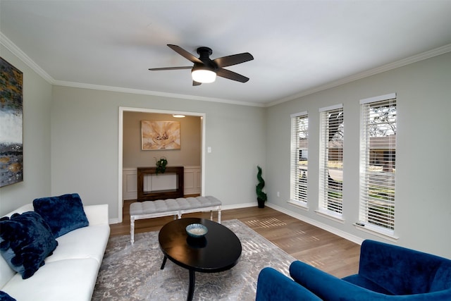 living room with ceiling fan, wood-type flooring, a wealth of natural light, and ornamental molding