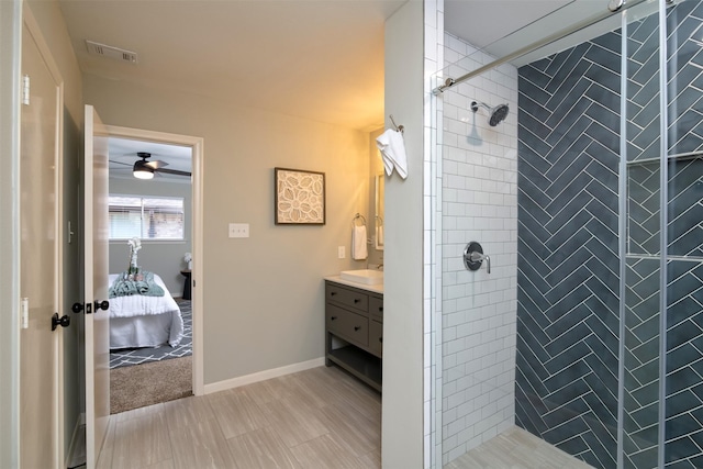 bathroom featuring ceiling fan, a tile shower, and vanity