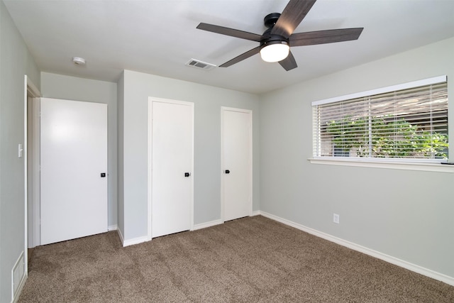 unfurnished bedroom featuring ceiling fan and dark carpet