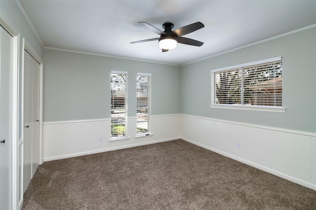 carpeted empty room featuring ceiling fan and crown molding